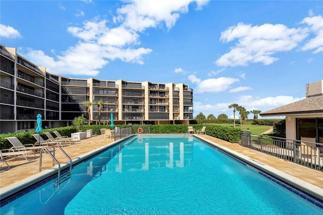 community pool featuring a patio and fence