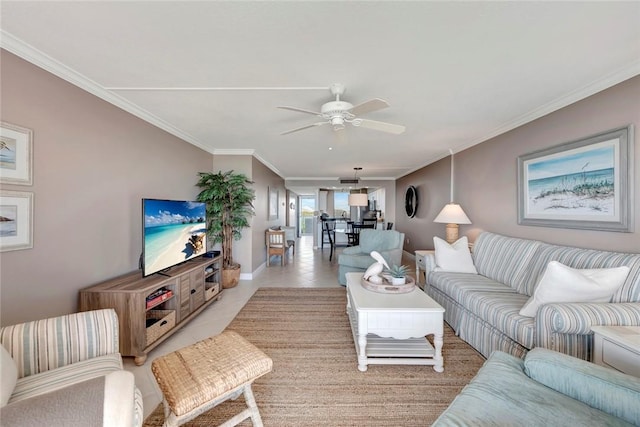 living area with ornamental molding, a ceiling fan, baseboards, and light tile patterned floors