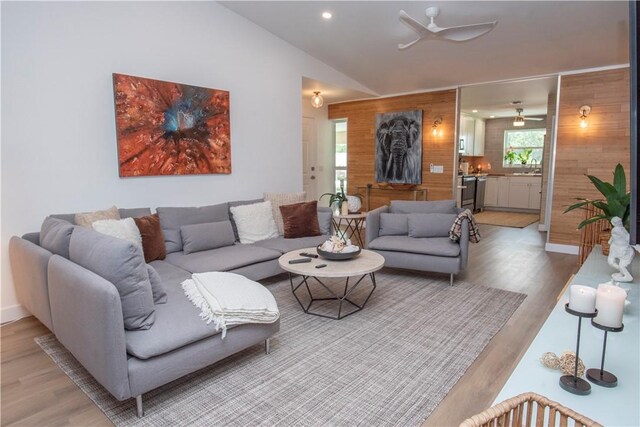 living room featuring hardwood / wood-style floors, ceiling fan, and lofted ceiling