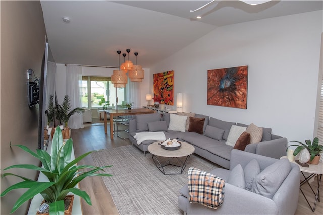 living room with light wood-type flooring and vaulted ceiling