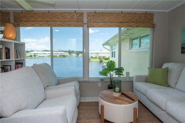 living room with tile patterned flooring, a healthy amount of sunlight, and a water view