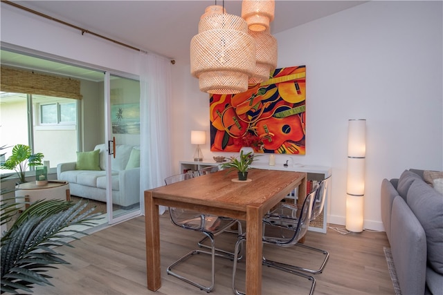 dining space featuring light hardwood / wood-style floors and an inviting chandelier