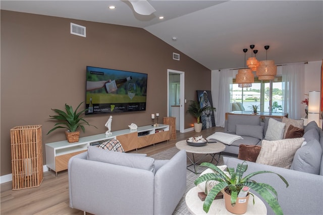 living room with light wood-type flooring and vaulted ceiling