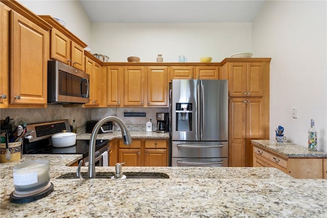 255 Grand Royale Cir Unit 204, Vero Beach, FL 32962 - kitchen with stainless steel appliances, light stone countertops, decorative backsplash, and brown cabinets