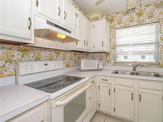 kitchen featuring white appliances, sink, light tile patterned flooring, and white cabinets