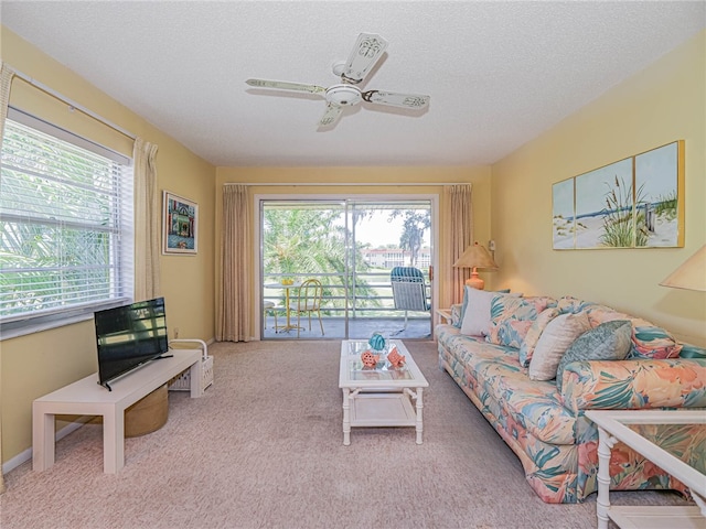 living room featuring light colored carpet, a textured ceiling, and ceiling fan