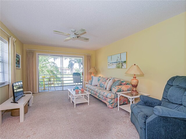 carpeted living room featuring a textured ceiling, a healthy amount of sunlight, and ceiling fan