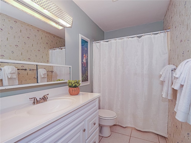 bathroom with toilet, vanity, and tile patterned floors