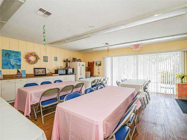 dining space featuring hardwood / wood-style floors and a textured ceiling