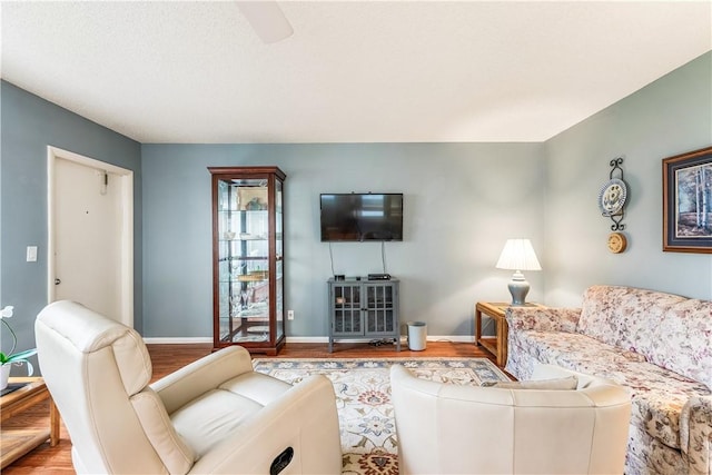 living area with wood finished floors and baseboards