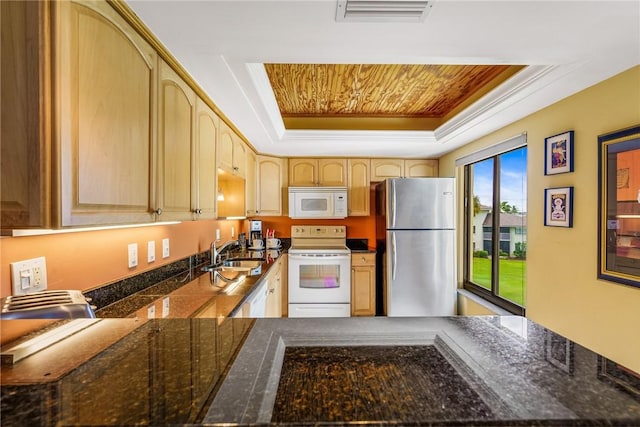 kitchen featuring light brown cabinetry, white appliances, a raised ceiling, and sink