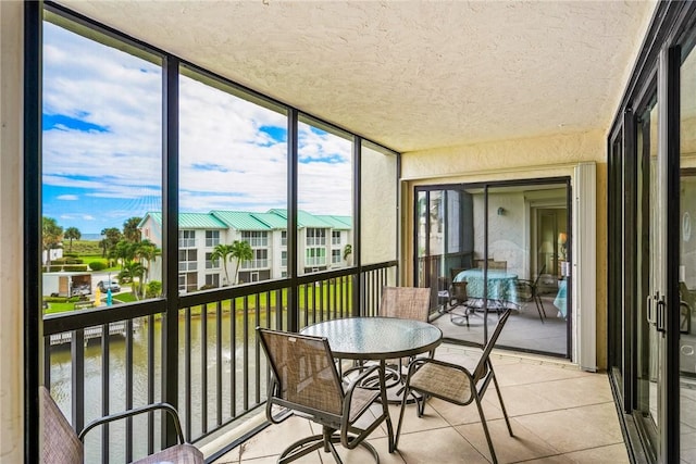 sunroom featuring a water view