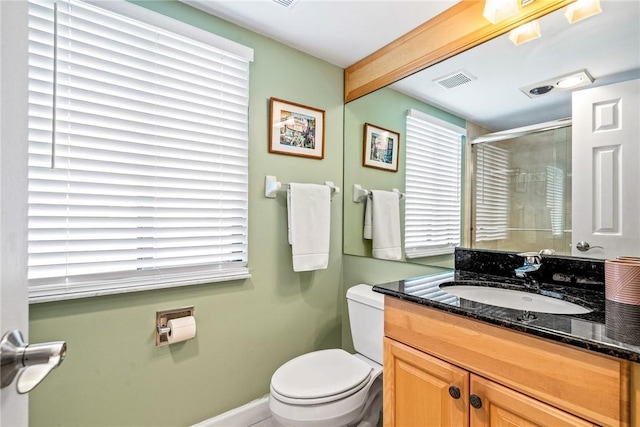 bathroom featuring toilet, vanity, and walk in shower