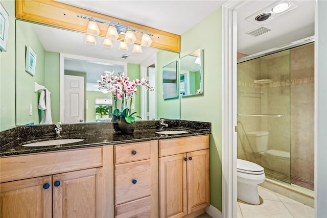 bathroom featuring tile patterned flooring, vanity, toilet, and an enclosed shower