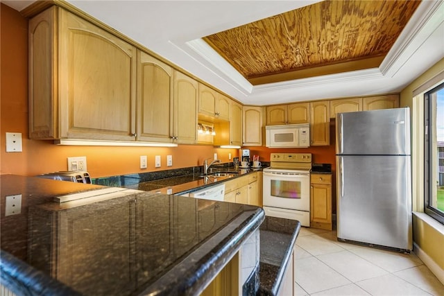 kitchen featuring white appliances, sink, ornamental molding, light tile patterned floors, and a tray ceiling