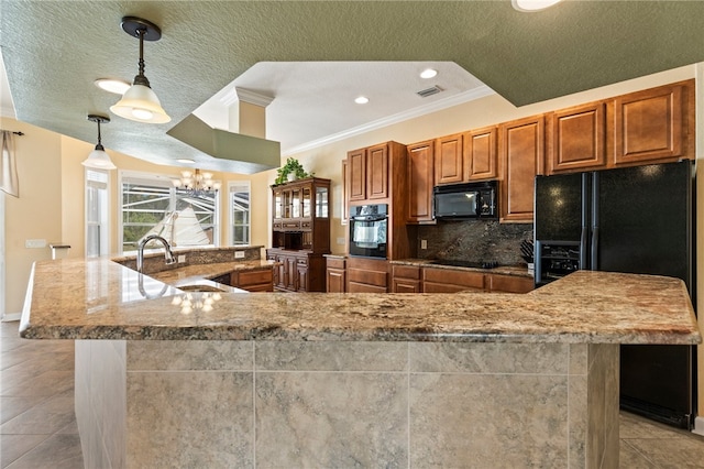 kitchen featuring sink, decorative backsplash, hanging light fixtures, a large island with sink, and black appliances