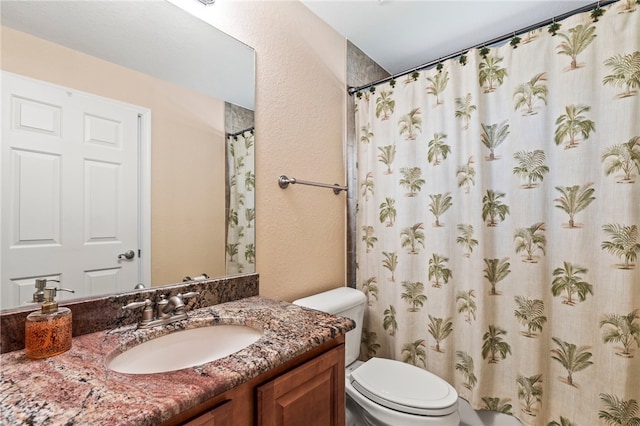 bathroom with vanity, curtained shower, and toilet