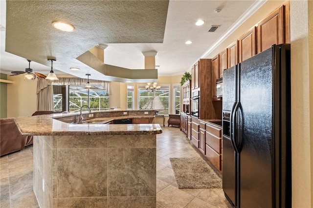 kitchen featuring sink, crown molding, light tile patterned floors, hanging light fixtures, and black fridge