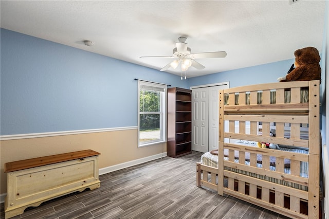 bedroom featuring ceiling fan, dark hardwood / wood-style flooring, and a closet