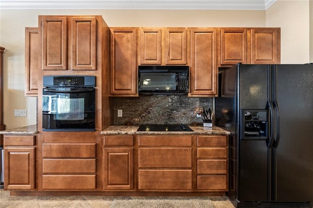 kitchen with backsplash, ornamental molding, dark stone countertops, and black appliances