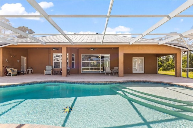 view of swimming pool featuring a patio, ceiling fan, and glass enclosure