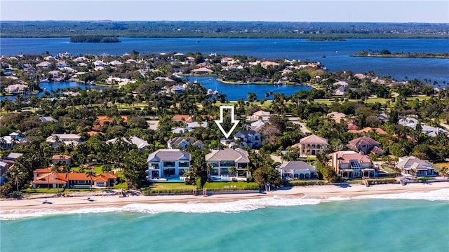 birds eye view of property featuring a beach view and a water view