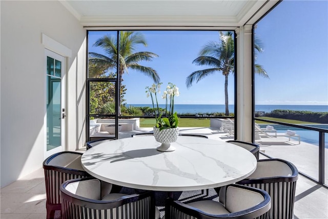 sunroom featuring a wealth of natural light and a water view