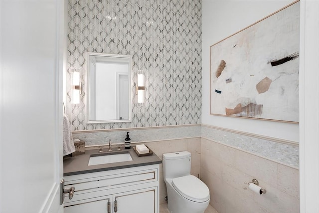 bathroom with vanity, tile walls, and toilet