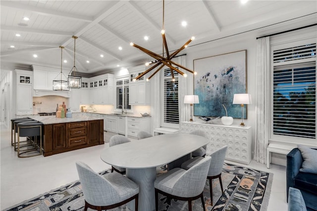 dining space with a chandelier, sink, lofted ceiling with beams, and wooden ceiling