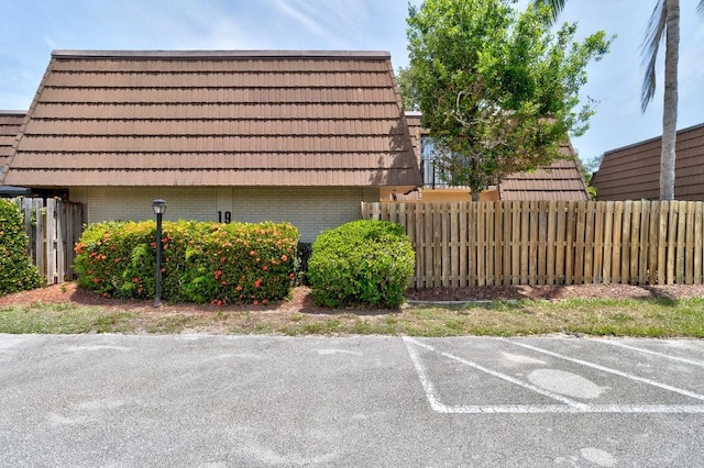 1166 6th Ave Unit 19C, Vero Beach, FL 32960 - view of property exterior with brick siding, uncovered parking, and mansard roof