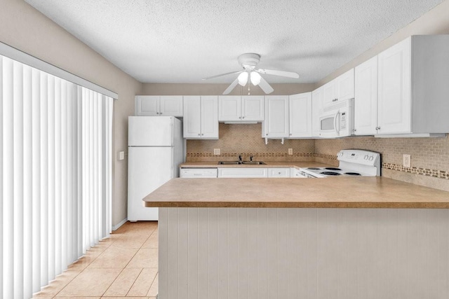 1166 6th Ave Unit 19C, Vero Beach, FL 32960 - kitchen featuring white appliances, a sink, a peninsula, light countertops, and backsplash