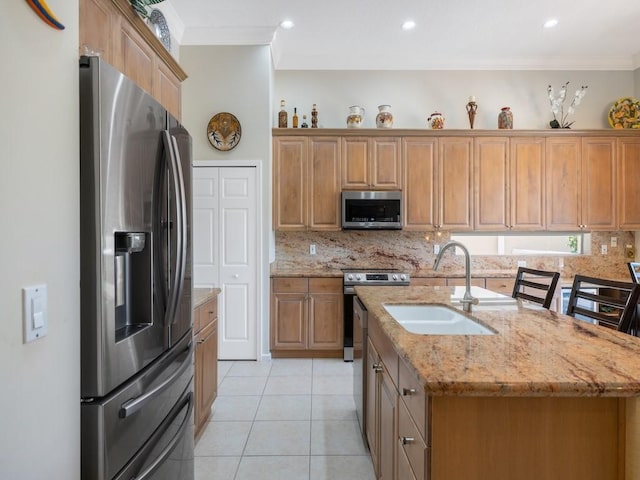 9535 E Maiden Ct, Vero Beach, FL 32963 - kitchen with stainless steel appliances, crown molding, a kitchen island with sink, tasteful backsplash, and light tile patterned flooring