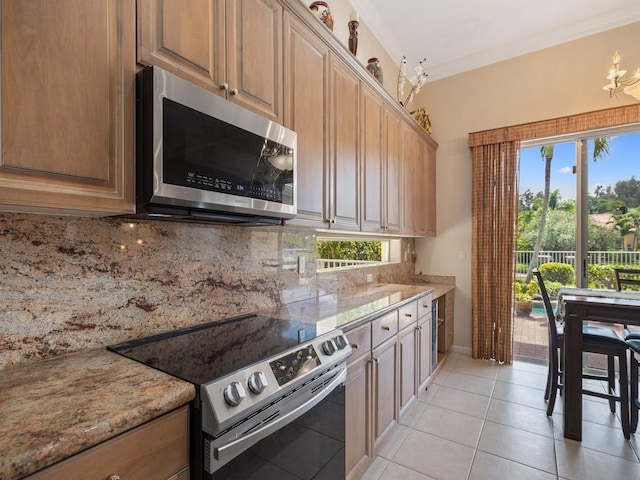 9535 E Maiden Ct, Vero Beach, FL 32963 - kitchen with stainless steel appliances, decorative backsplash, light tile patterned floors, and light stone counters