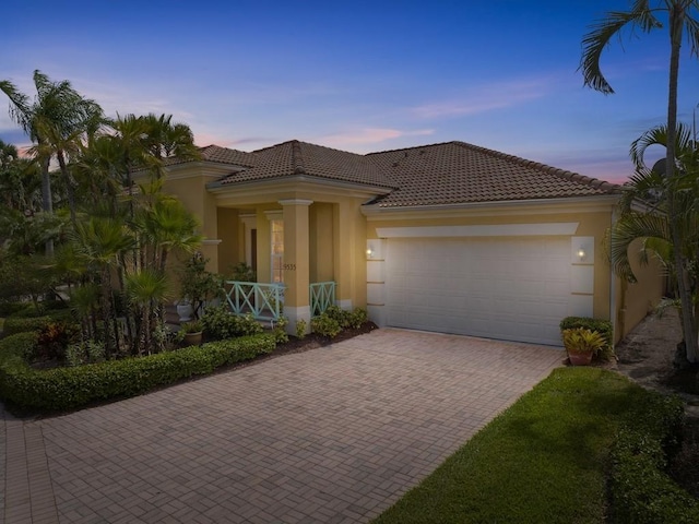 9535 E Maiden Ct, Vero Beach, FL 32963 - mediterranean / spanish home with decorative driveway, a garage, stucco siding, and covered porch
