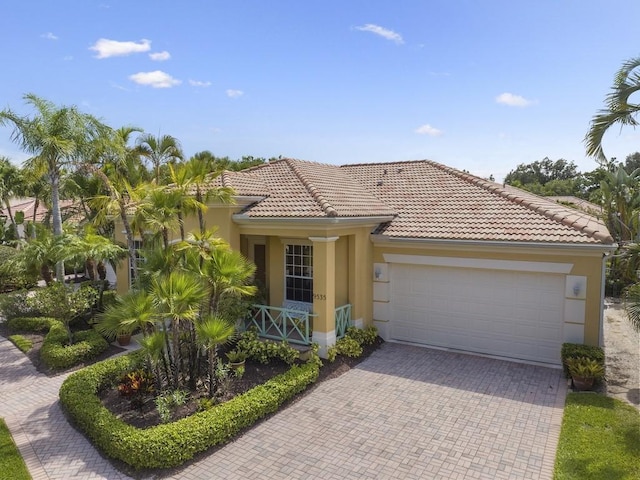 9535 E Maiden Ct, Vero Beach, FL 32963 - mediterranean / spanish house featuring stucco siding, a garage, decorative driveway, and a tile roof