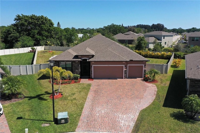 view of front of house with a front yard, fence, a garage, stone siding, and decorative driveway