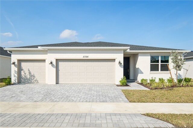 ranch-style house featuring a garage and a front lawn