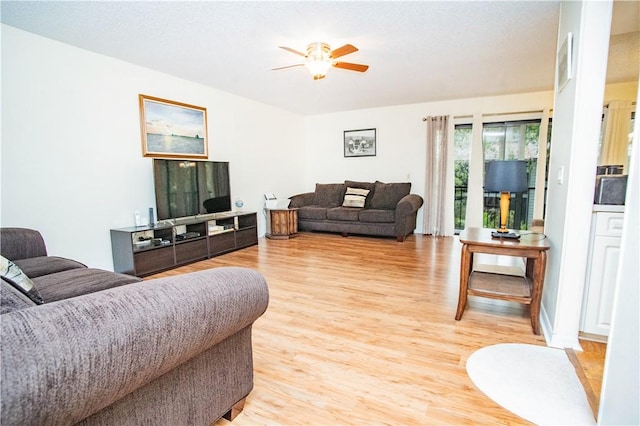 living room featuring ceiling fan and light wood-type flooring