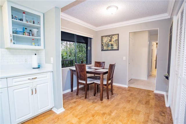 dining space with a textured ceiling, built in features, and crown molding