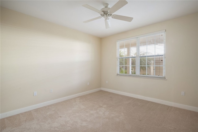 spare room featuring ceiling fan and light carpet