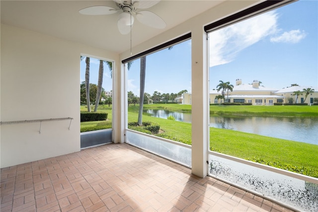 unfurnished sunroom with a water view and ceiling fan