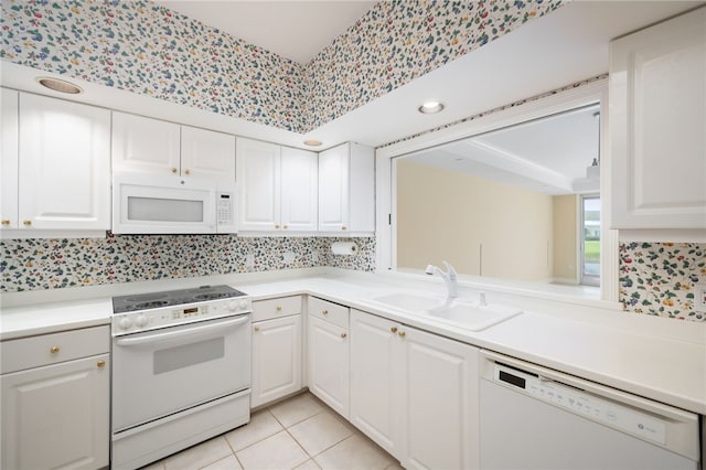 kitchen featuring white cabinetry, light tile patterned flooring, white appliances, and sink