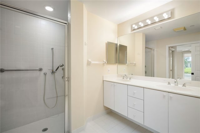 bathroom with tile patterned floors, a shower with door, and vanity