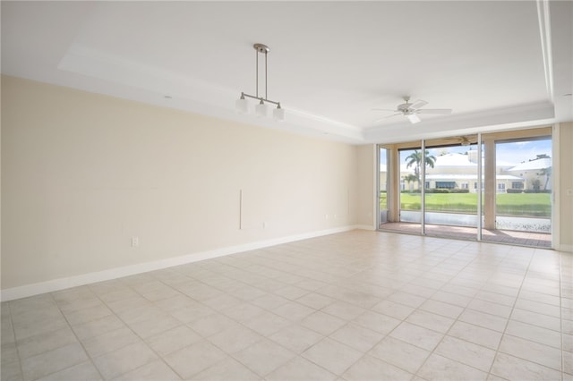 tiled spare room featuring a tray ceiling and ceiling fan