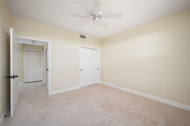 unfurnished bedroom with ceiling fan, a closet, and light colored carpet