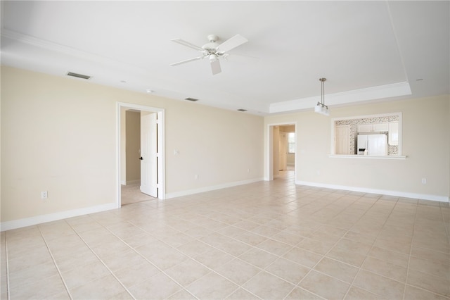 tiled spare room with a tray ceiling and ceiling fan