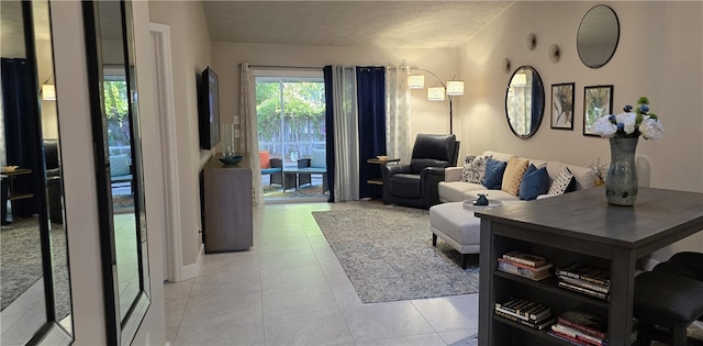 living room with a textured ceiling and light tile patterned floors