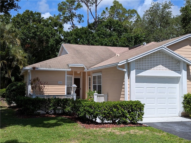 ranch-style house featuring a garage and a front lawn