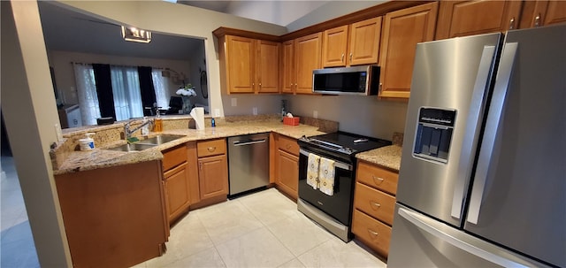 kitchen featuring appliances with stainless steel finishes, sink, light stone counters, and light tile patterned floors