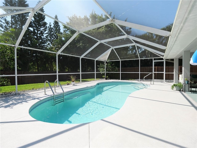 view of swimming pool featuring glass enclosure and a patio area